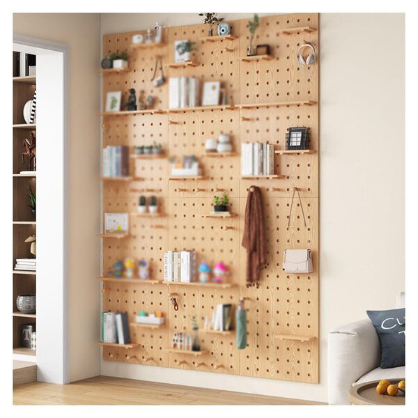 Organized pegboard system with labeled containers, office supplies, and tools mounted on a white wall behind a desk workspace