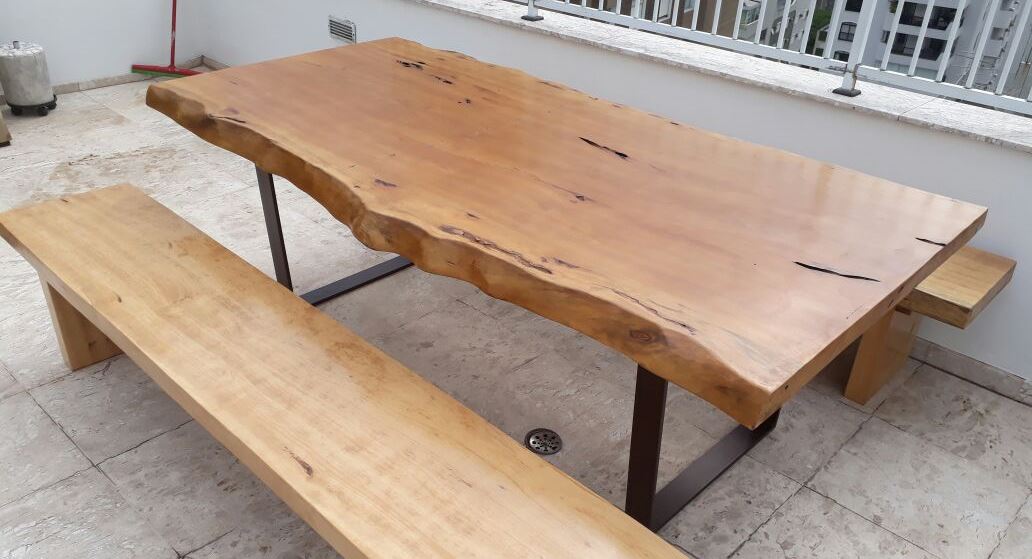 Mesa de jantar retangular com um banco de madeira em um dos lados.
