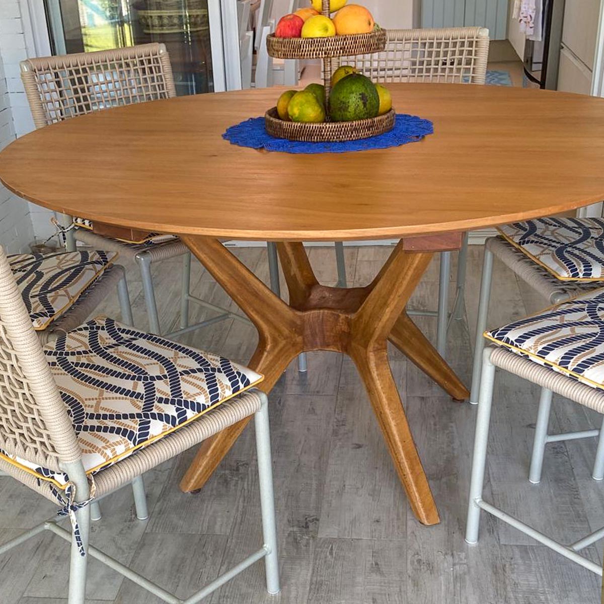 Mesa de jantar retangular de madeira rústica em uma sala de jantar espaçosa.