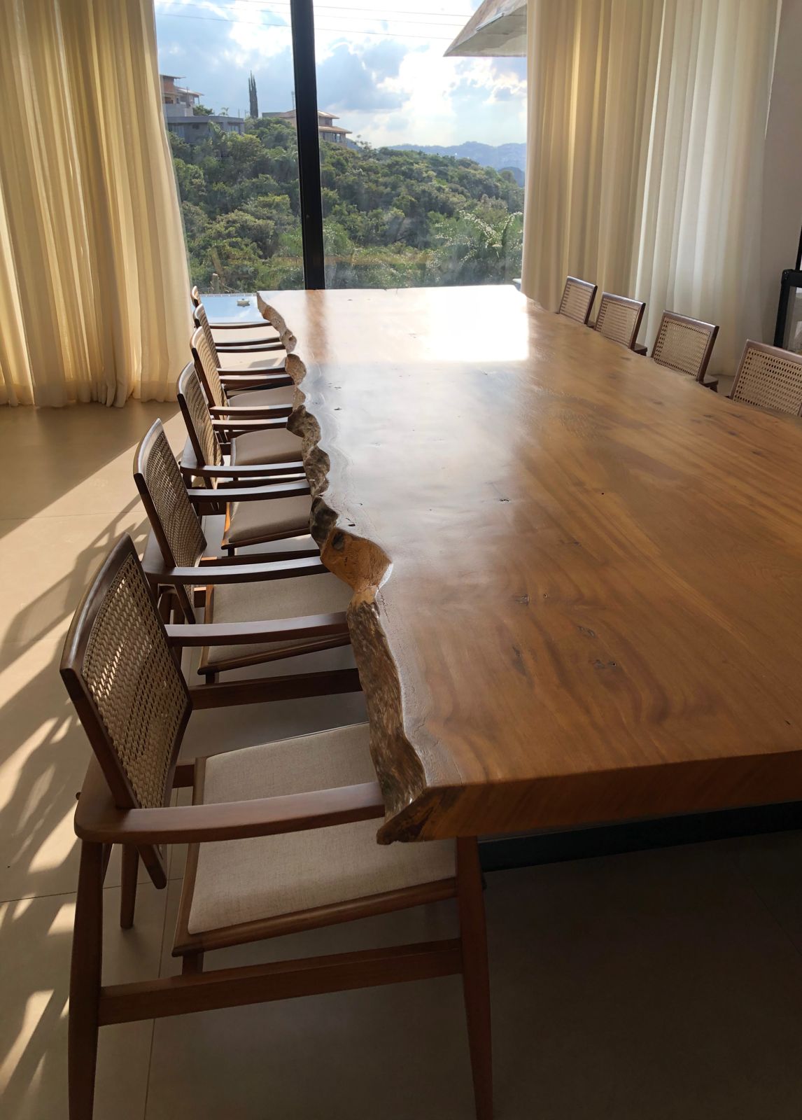 Mesa de jantar de madeira maciça com bordas orgânicas em ambiente moderno