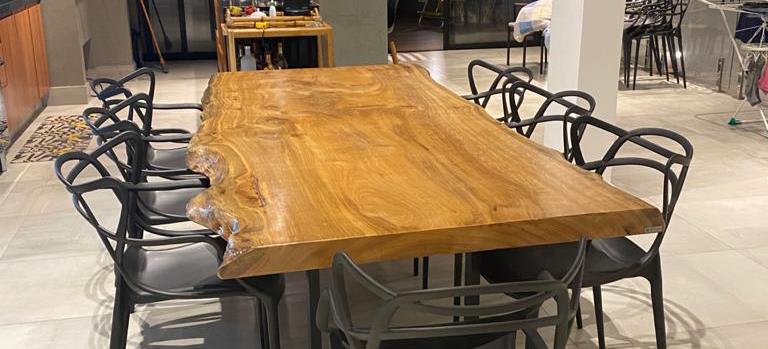 Sala de jantar pequena e bem decorada com uma mesa de madeira redonda.
