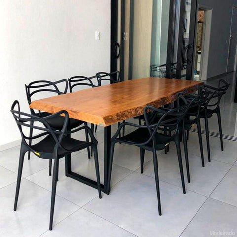 Detalhe de uma mesa de jantar rústica com cadeiras sobre um tapete