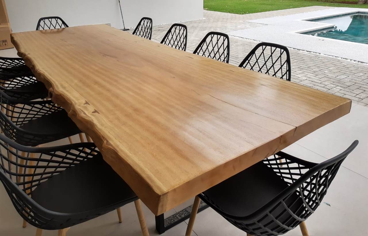 Mesa de jantar de madeira maciça com cadeiras modernas em ambiente clean