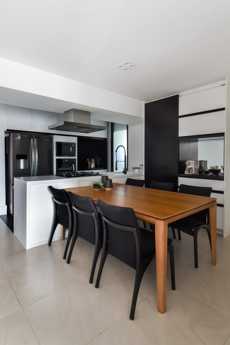 Ambiente integrado com cozinha e sala de jantar com mesa de madeira retangular